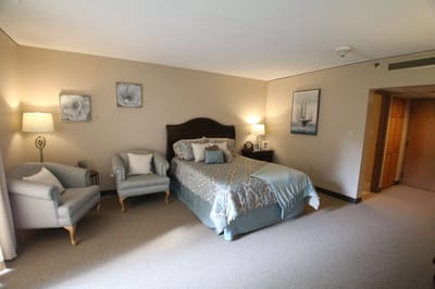 Cozy, well-decorated resident room with a bed and seating area