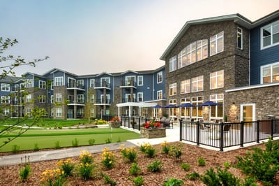 Exterior view of a senior living facility with landscaped gardens