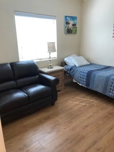 Cozy interior of a resident's room with a bed and seating area