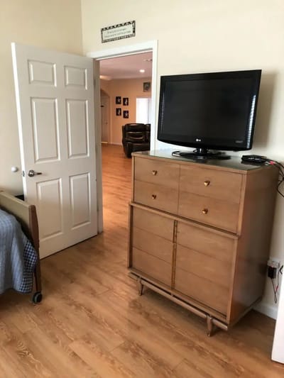 View of a resident room with a TV and dresser