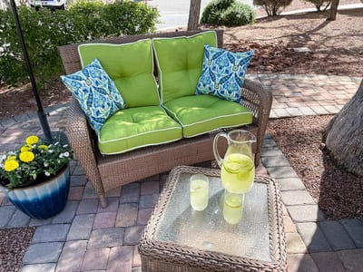 Outdoor seating area with green cushions and refreshments
