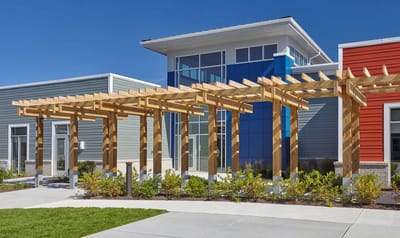 Outdoor entrance with wooden trellis and contemporary building facade