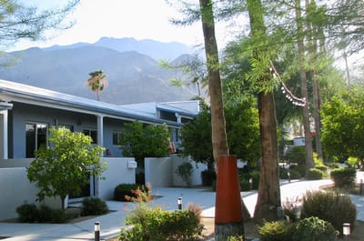 Outdoor view of a senior living facility with trees and mountains