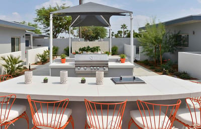 Outdoor barbecue area with seating and landscaping