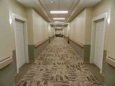 A hallway with beige walls and patterned carpet