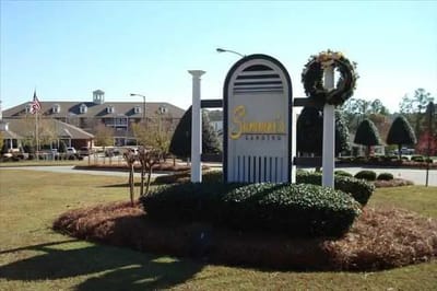 Facility logo sign outdoors with landscaping.