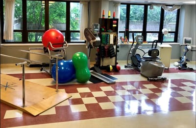 Physical therapy room with equipment and therapy aids