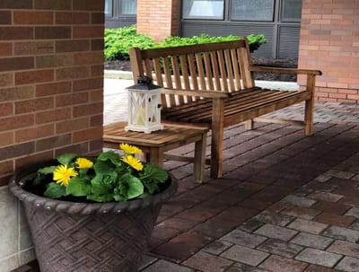 Outdoor seating area with a wooden bench and flowers