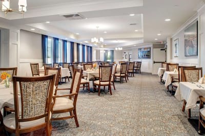 Bright dining room with tables set for residents