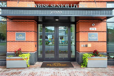 Front entrance of Sunrise Senior Living with welcoming planters