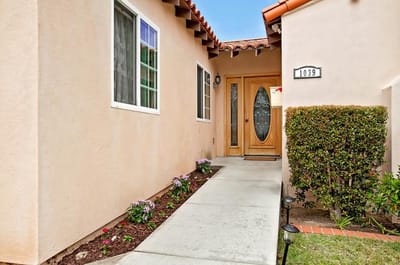 Entrance to a senior care facility with flowers and a door