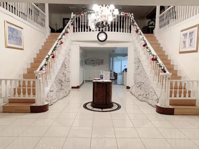 Interior view of a spacious entryway with stairs and decorations