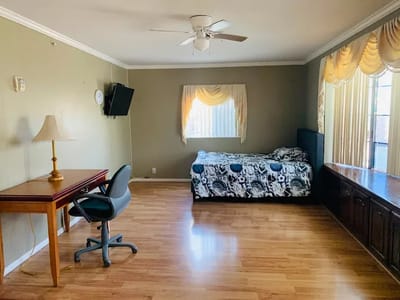 Bright private resident room with a bed and desk