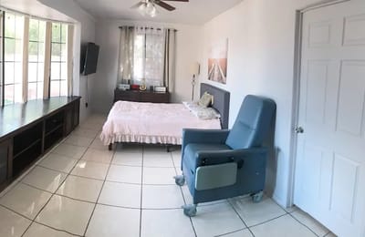 Bright, spacious resident room with a bed and chair