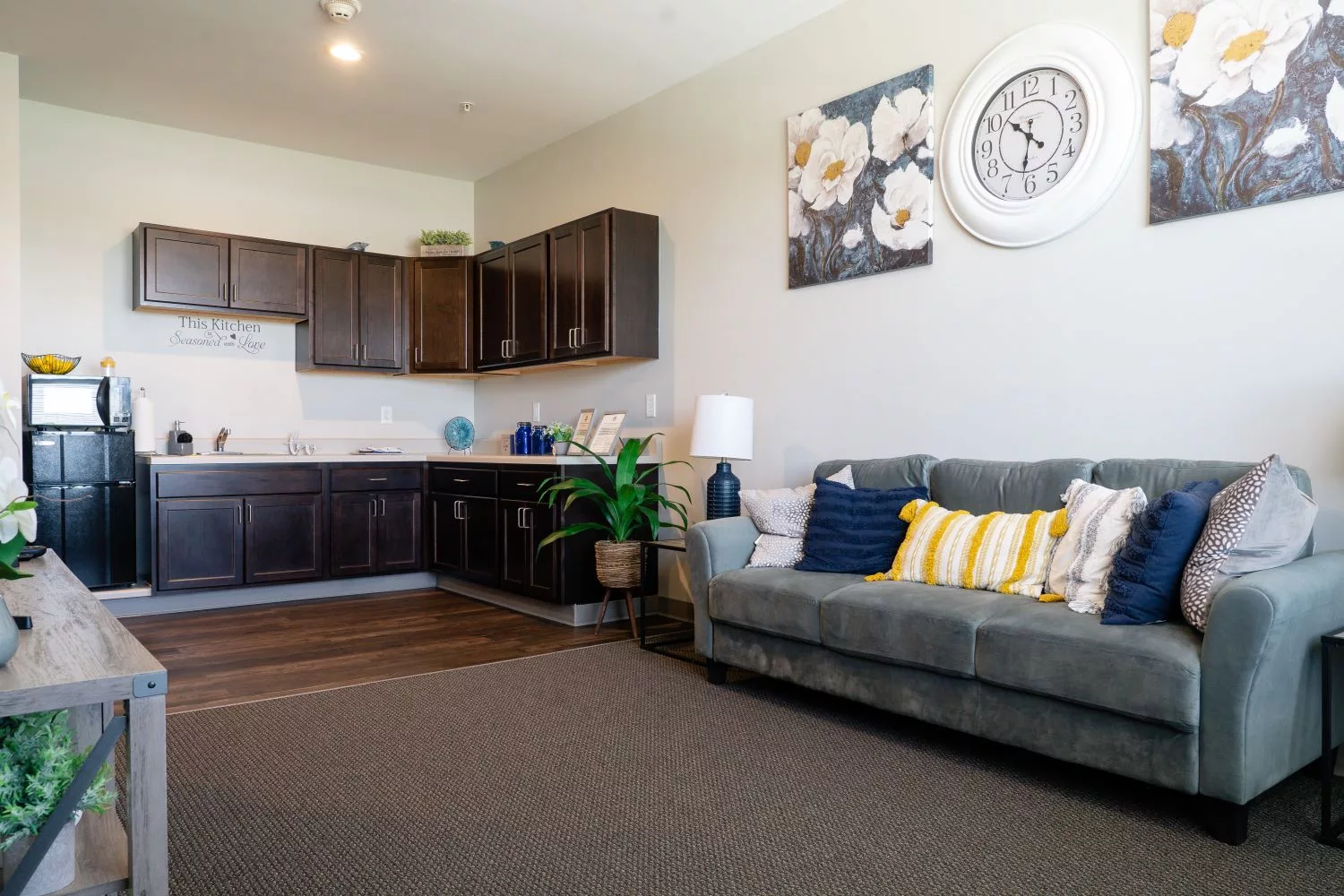 Cozy interior of a senior living unit with a couch and kitchen area