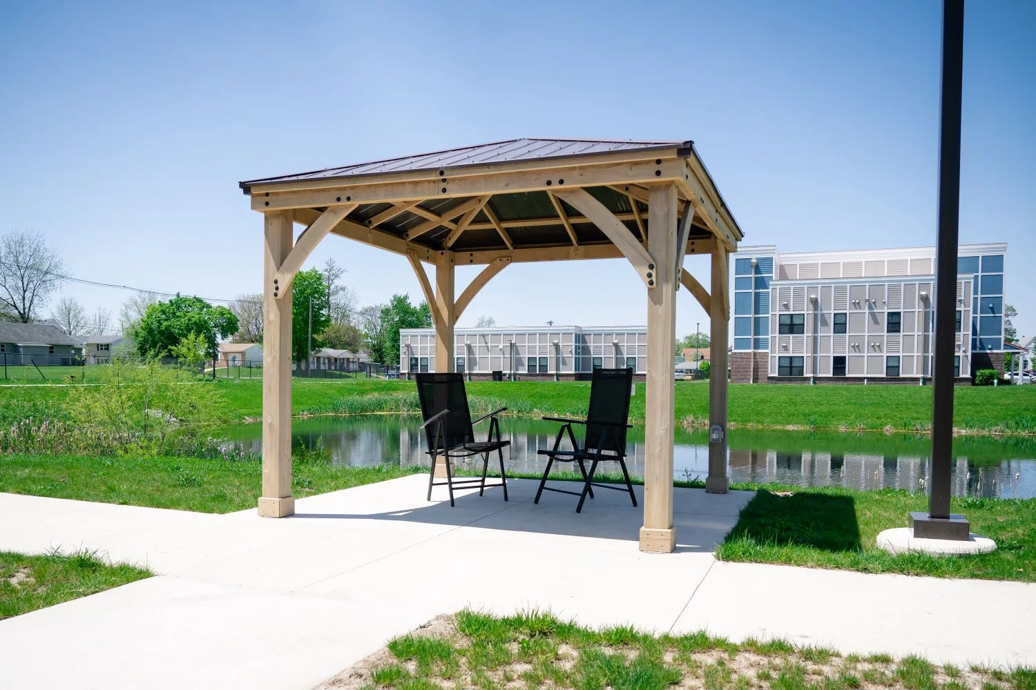 Outdoor gazebo by a pond with seating