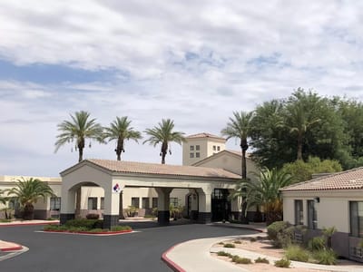 Exterior view of the TLC Care Center entrance with palm trees