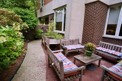 Outdoor seating area with planters and lush greenery