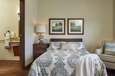 Well-decorated private resident room with a cozy bed
