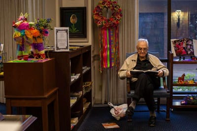 Resident reading in a common area decorated for an event