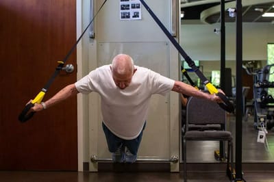 Senior man exercising with resistance bands in a gym