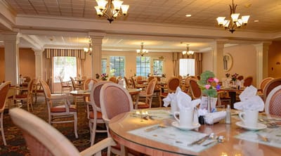 Dining room with elegantly set tables and flowers