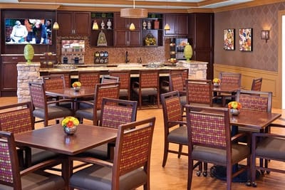 Dining room with tables, chairs, and a kitchen area