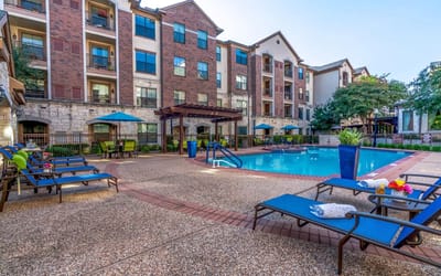 Outdoor pool area with lounge chairs and umbrellas