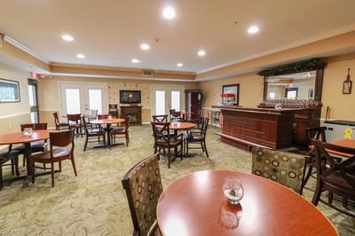 Common area with tables and a bar in the background