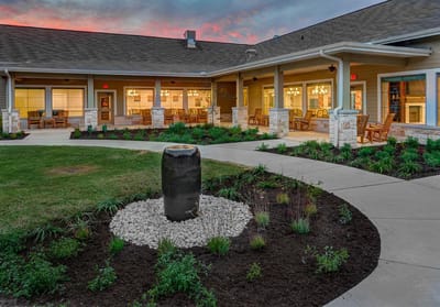 Exterior view of a senior living facility with garden