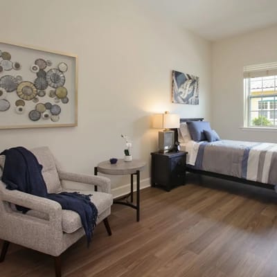 A cozy private room with a bed and chair