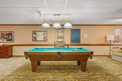 A game room with a pool table and seating area