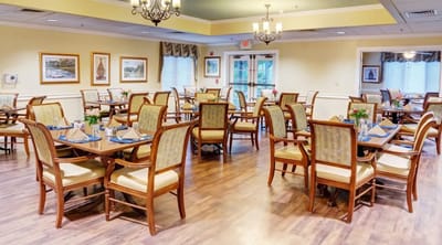 Bright dining room set up for meals with floral centerpieces