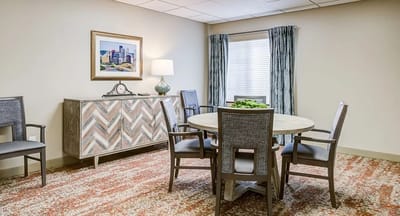 Brightly lit interior of a common area with a dining table.