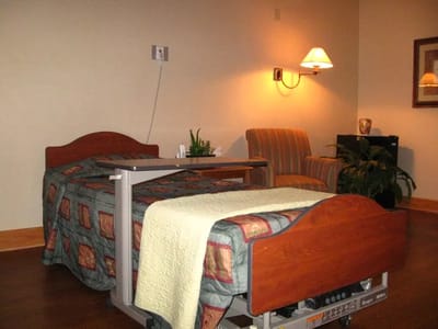 A private resident room with a bed and chair
