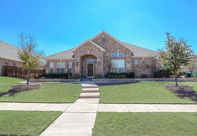 Exterior view of a senior living facility with landscaped front yard