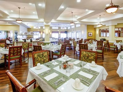 Dining room setup with tables and chairs for residents