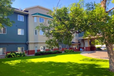 Exterior view of a senior living facility surrounded by greenery