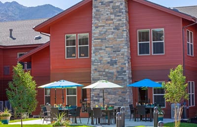 Exterior view of a senior living facility with outdoor seating