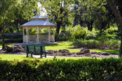 A serene garden with a gazebo and bench