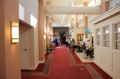 Bright interior corridor with residents and staff