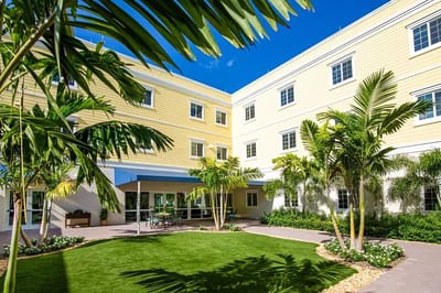 Garden area surrounded by a building with palm trees