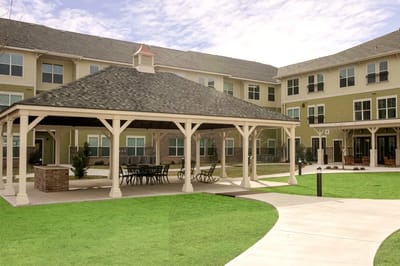 Outdoor gazebo area with seating in a landscaped setting