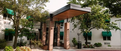Entrance of a senior living facility with greenery