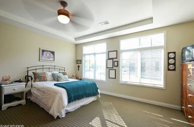 A well-furnished resident room with light coming through windows