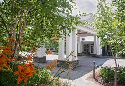 Exterior view of The Residence at Otter Creek entrance with flowers