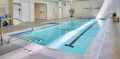 A bright indoor pool area with accessible features