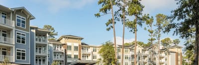 Exterior view of a senior living facility surrounded by trees