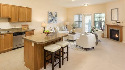 Cozy living room with kitchen area in a senior living unit