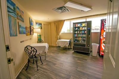 Interior view of a common area with tables and vending machine